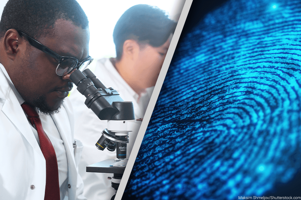 African American man looking through a microscope at fingerprints