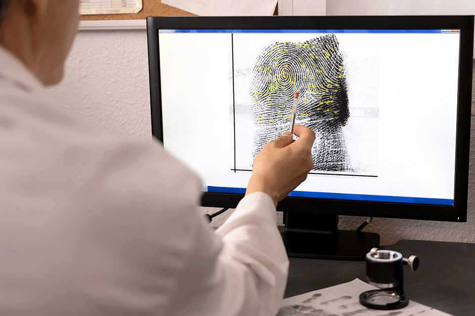 An analyst examining a fingerprint on a computer screen